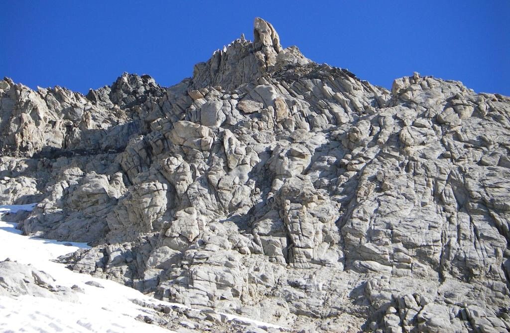 From the tongue of snow with the little rock mostly in shadow we climbed up right in a gully then across a ledge/ramp to the little notch on the right skyline. Judi Steciak Photo