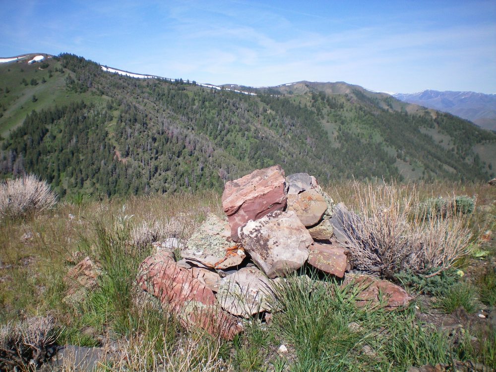 The summit cairn atop Peak 7374 with the long Northeast Ridge of Peak 7921 in the background. The summit of Peak 7921 is at the upper left corner of the photo. Livingston Douglas Photo