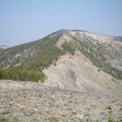 Goldstone North as viewed from the south on the Continental Divide. The summit hump is the small, darkish mound in dead center. Livingston Douglas Photo