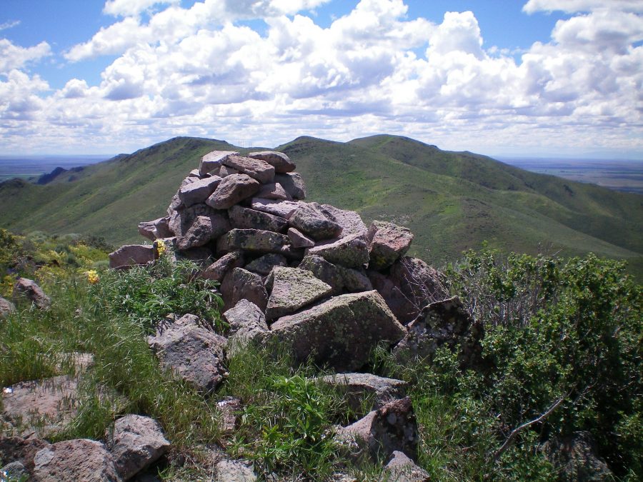 The summit cairn atop Peak 6025 looking south. Peak 6145 is the most distant hump right of center. The ridge traverse to get there is a tedious endeavor with lots of weaving and ups/downs. Livingston Douglas Photo