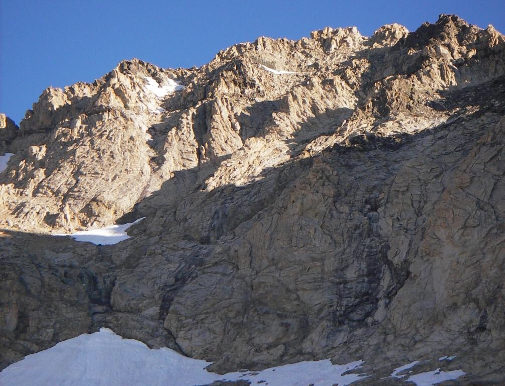 S face of Brocky. Our route started at the very far left snowfield, traversed up to the black dike via a gully and ledge, crossed into the first bowl, crossed into the second bowl, reached the notch on the skyline to the left of the black rock, and went back left over the first bump to the second bump (summit). Judi Steciak Photo