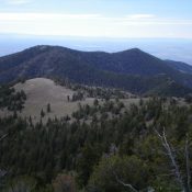 Peak 9300 is the forested ridge hump in the distance (left of center), as viewed from the summit of Bloom Benchmark. Livingston Douglas Photo