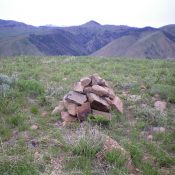 The summit cairn atop Peak 7422 with pyramidal-shaped Peak 8324 in the background (middle of photo). Livingston Douglas Photo