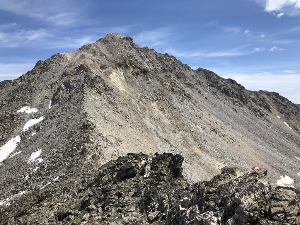 Not essential info for climbers, but the south face of Altair recently had a large chunk of earth slide off of it. (The white area on the photo.) A USFS worker was working on rebuilding the section of trail that got buried. Away from all the rubble was a car-sized rock that stopped directly on the trail. There were 2 register entries from 2018 and one of them mentioned the slide, so it’s been there for at least a year. Photo and commentary by Derek Percoski