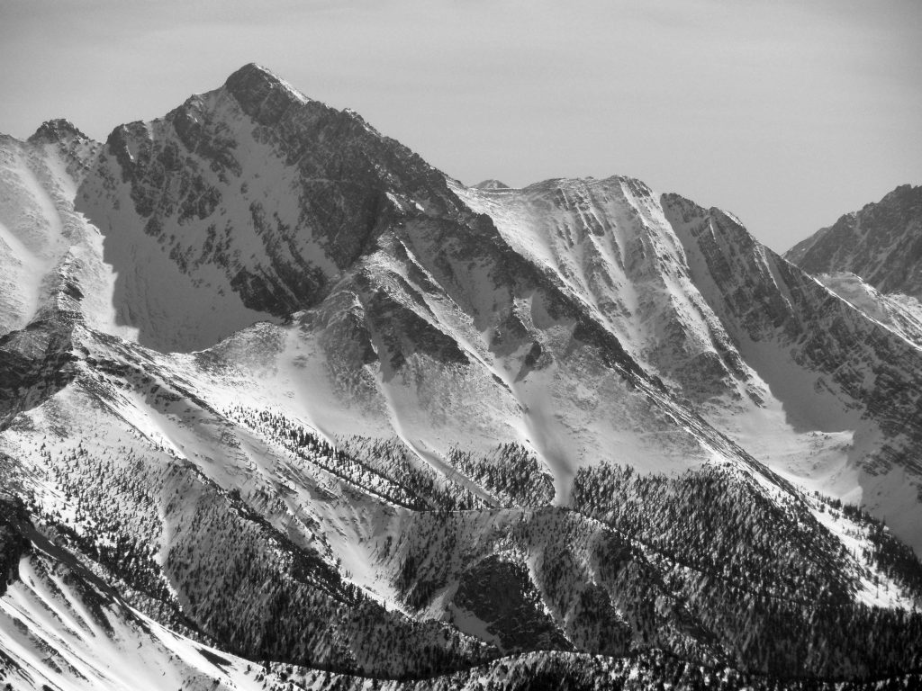 The Northwest Ridge is in the center of the photo. This ridge splits into two separate ridges lower down on the mountain, one into the Rock Creek drainage and the other forms the edge of the West Face. The Southwest (Chicken-Out) Ridge is on the right skyline. Photo by John Platt