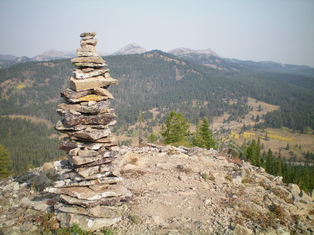 A very tall cairn atop a ridge point on the northwest spur of the north ridge of Peak 8386. Peak 8340 is the forested mountain in the center of the photo (mid-ground). Livingston Douglas Photo 