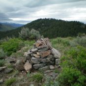 The newly-rebuilt summit cairn atop Peak 7042 with Peak 7283 in the background. Livingston Douglas Photo