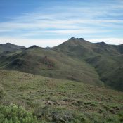 The magnificent pyramidal summit of Peak 7585 (dead center) and its south spur (left of center) and west ridge (leading rightward from the south spur) as viewed from the summit of Peak 6940 to its southwest. Livingston Douglas Photo