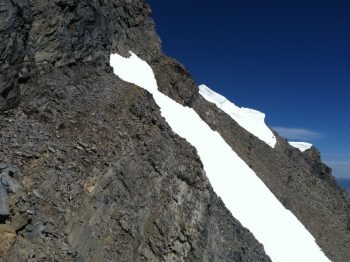 The key to the climb. A tiny col where the East Ridge meets the upper East face. Cross the snow field "sky ledge" to get to the summit. Photo - Wes Collins