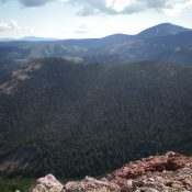 The thickly forested, ridgeline hump that is Peak 9115. The summit is left of center. Point 9097 is right of center. Livingston Douglas Photo