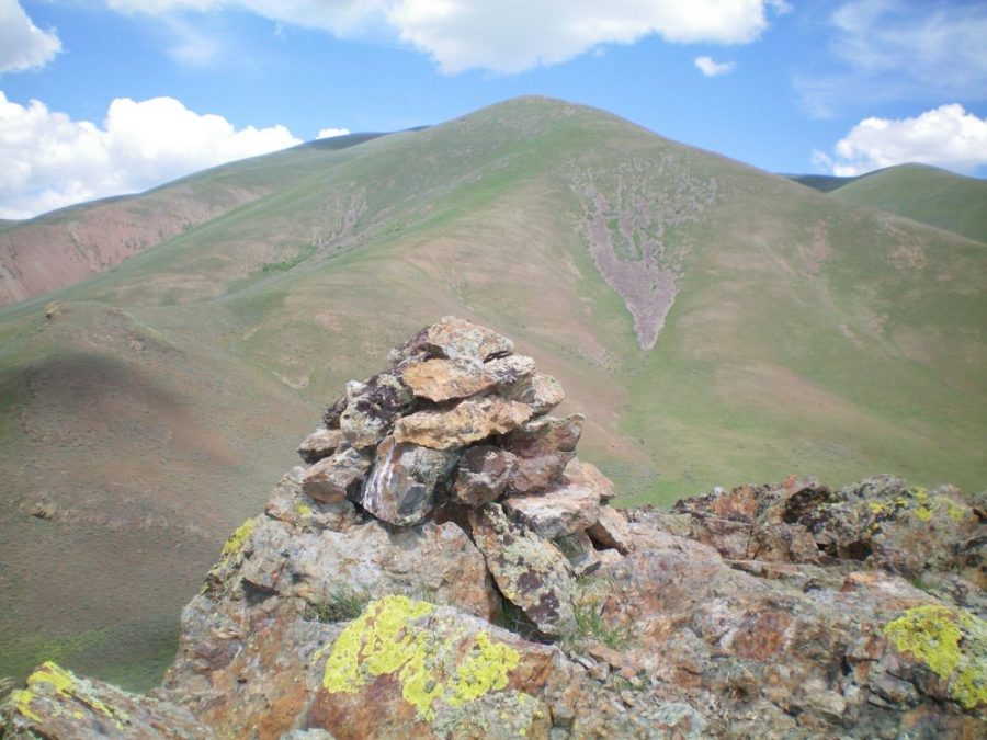 The summit cairn atop Peak 5764 with Peak 7900 in the background. Livingston Douglas Photo