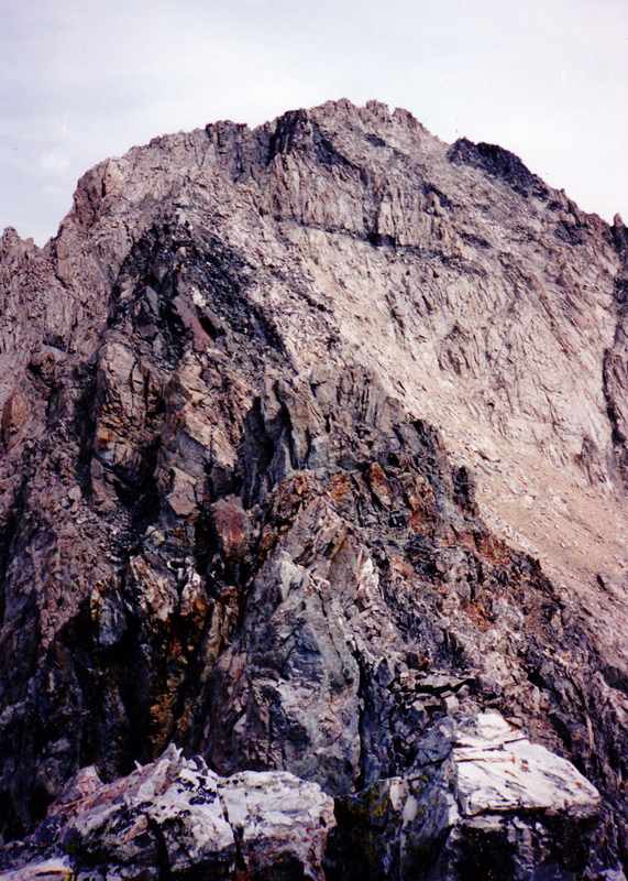 Starting in the foreground, the knife edge south ridge of Brocky Peak connects with the face behind it. The Class 4-5 route starts with a "au cheval" move. A slightly easier approach to Brocky's summit is to down climb from this point and then climb the face farther to the right. Rick Baugher Photo and Commentary