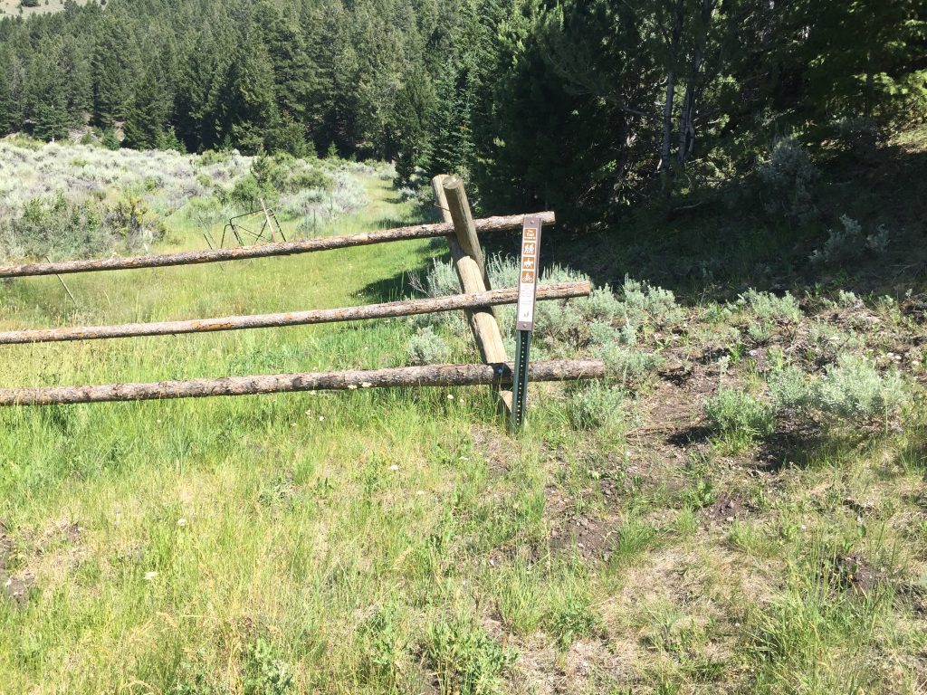 The trail starts behind this fence