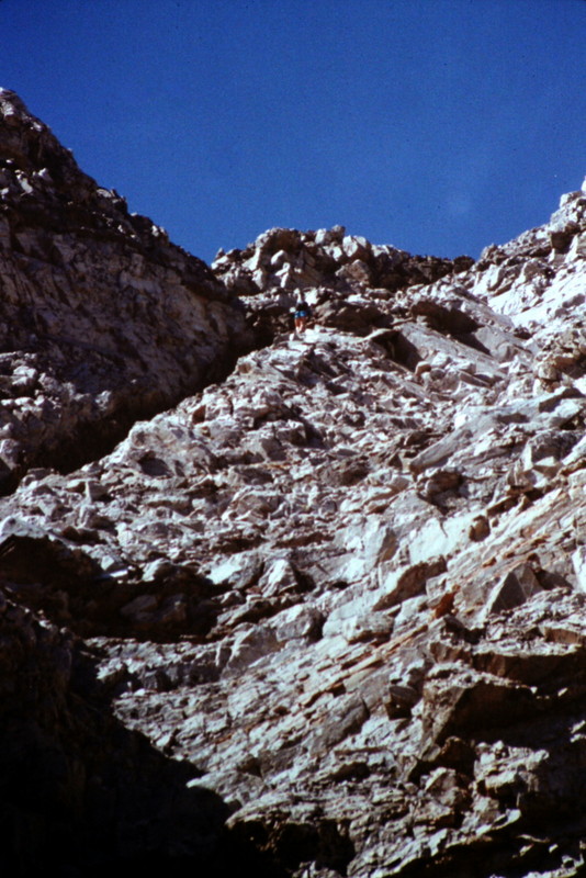 A closer view of the dike with a climber nearing its top end.