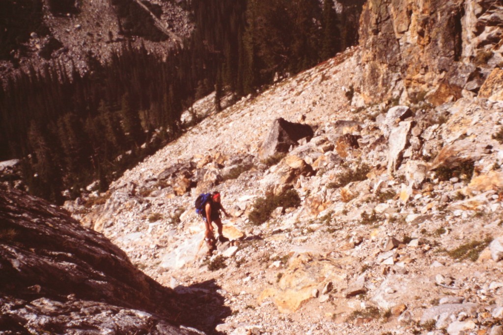 The approach crosses a lot of broken rock. The climber is approaching a gully that leads to the top of the ridge.