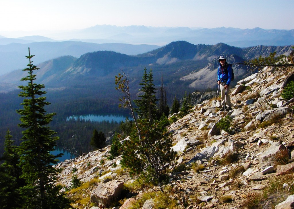 Carl Hamke high on the south ridge with Rocky Lake and Langer Lake below, and the Sawtooth Mountains in the distance. Judi Steciak Photo