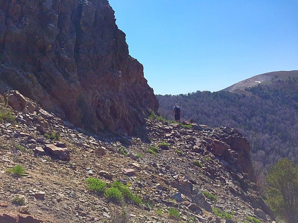 The base of the west ridge. Proceeding past the climber, will lead across the base of the ridge to a point where you can ascend the face. Turn left at this point and climb the opening in the cliff to begin the ascent of the west ridge.